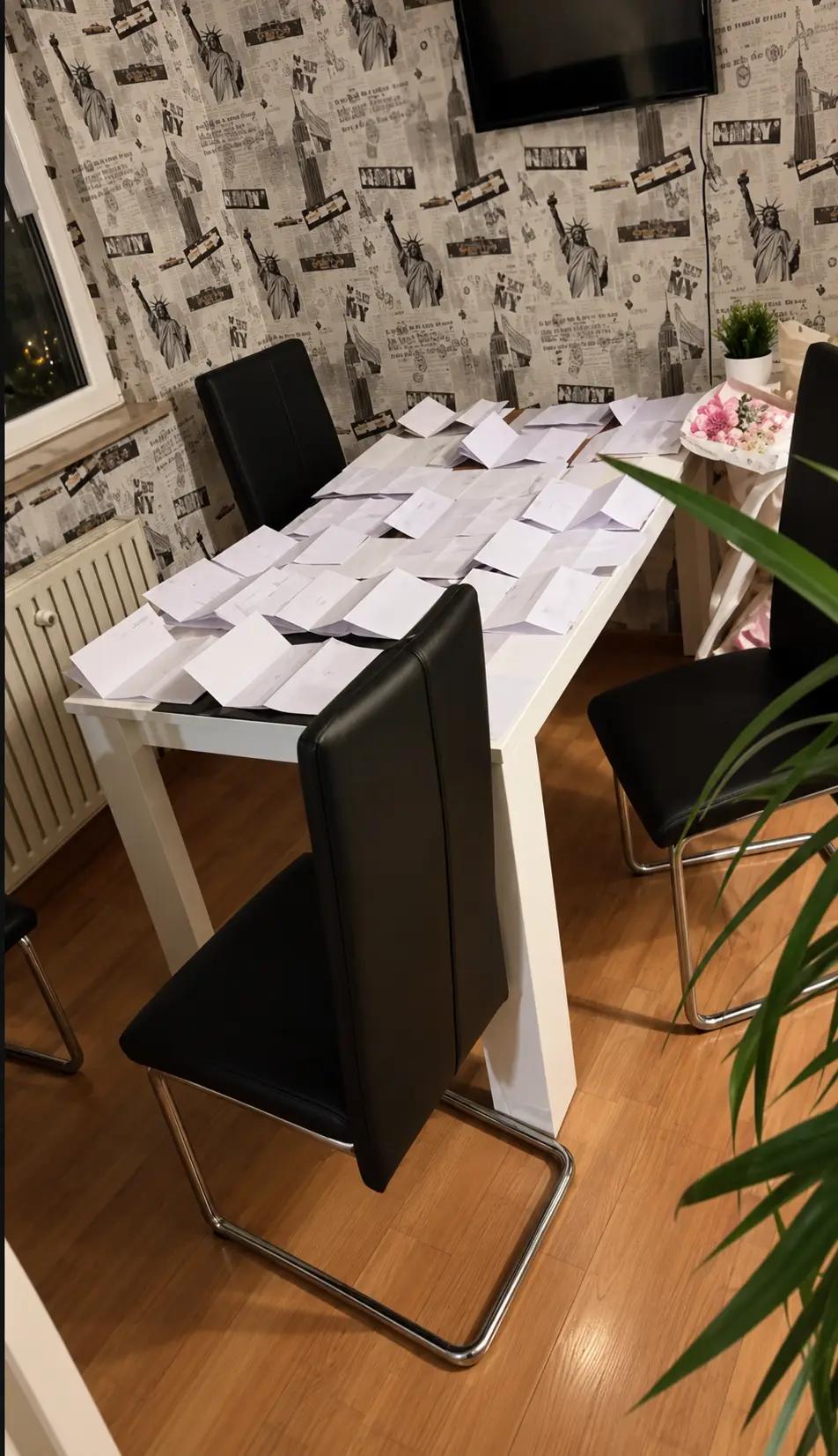 Esszimmer mit Papierstapeln und Fernseher